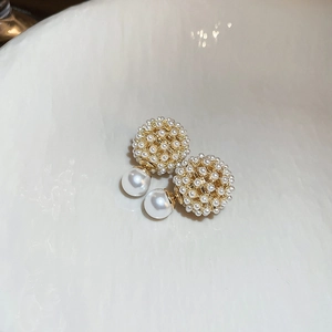 Detailed close-up of French-style hollow sphere earrings with tiny pearls and gold plating