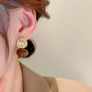 Close-up of vintage flower heart earrings with gold textured metal and amber resin beads