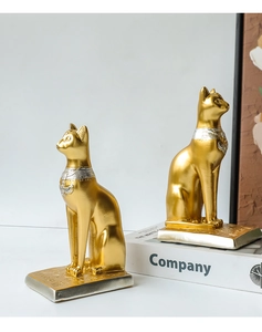 Detailed close-up of golden Egyptian Bastet cat statues with engraved hieroglyphic bases