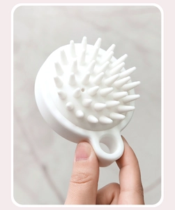 Macro shot of white silicone scalp massager brush with ergonomic grip for hair washing