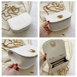 Detailed view of the white saddle bag showing shell clasp and chain strap features