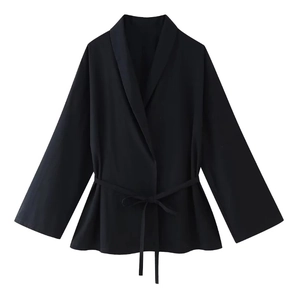 Detail of black woven wrap top featuring a tie-waist closure and long sleeves