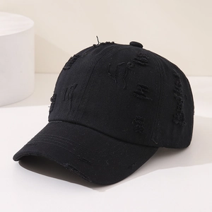 Close-up of black washed cotton baseball cap with distressed torn holes and street style