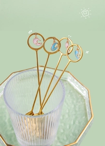 Detailed macro view of golden stainless steel dessert spoons with moon and star charms