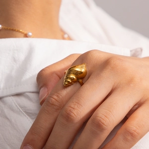 Detailed view of an elegant golden conch shell ring featuring intricate spiral textures