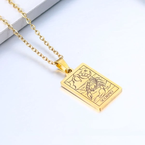 Macro shot of Scorpio gold rectangular pendant necklace on white geometric stand