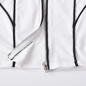 Close-up of white ribbed tank top featuring black contrast piping and silver metal zipper