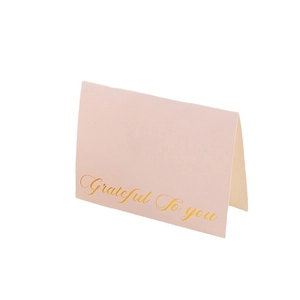 Pink gold-foiled greeting card with Grateful To You text on a white background