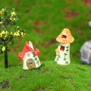 Miniature resin cottage models with red and orange roofs on mossy green lawn decor