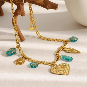 Détail du collier à pendentif cœur plaqué or 18 carats avec perles bleues sur fond texturé