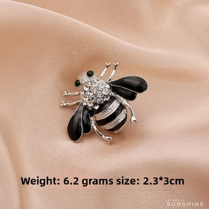 Detail shot of a crystal bee brooch weighing 6.2g and measuring 2.3x3cm with green gem eyes