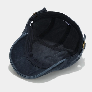 Dettaglio della fascia tergisudore nera e della fibbia in metallo del berretto in denim lavato