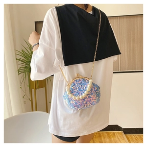 Rear view of model wearing a blue sequin mini round bag with pearl handle and chain