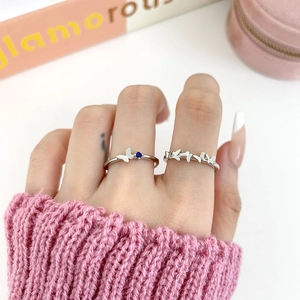 Blue zircon butterfly ring set in silver finish on hand with a soft lifestyle background