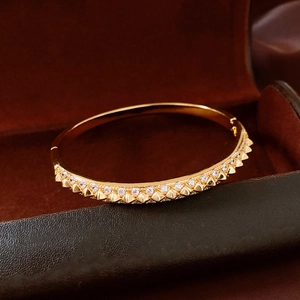 Detail of 18K gold plated rivet bangle with inlaid crystals on velvet box