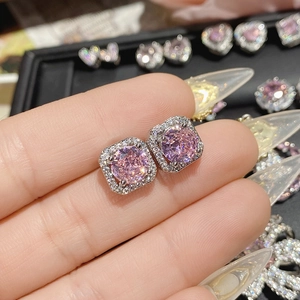 Macro shot of 18K gold pink heart earrings featuring cubic zirconia and bow detail