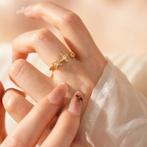 Nahaufnahme eines goldenen Schmetterlingsrings mit Zirkonia am Finger, Vintage-Stil