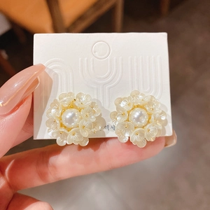 Elegant floral stud earrings with white flower clusters and pearls on golden backing