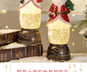 Close-up of bronze Christmas lantern snow globe with Santa Claus and glitter effect