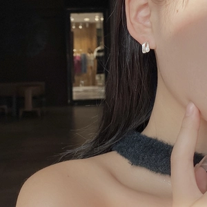 Close-up of minimalist S925 silver pearl stud earring worn on model's ear