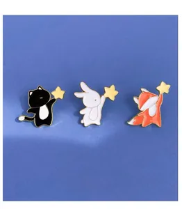 Detail of cute enamel pins featuring cat, rabbit and fox holding yellow stars