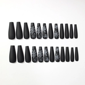 Long coffin-style press-on nails in matte black with white snowflake festive patterns