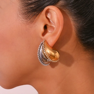 Gros plan d'un mannequin portant des boucles d'oreilles gouttes bicolores or et argent