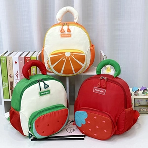 Detailed view of children fruit-shaped backpacks in orange, watermelon and strawberry designs