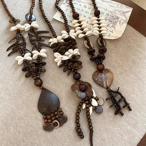 Detailed close-up of bohemian wooden beads and shell heart pendants on ethnic necklace