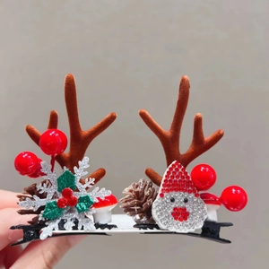 Close-up of Christmas reindeer antler hair clips with festive berries and Santa detail