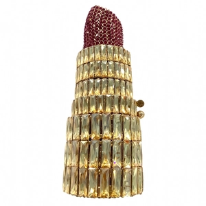 Detail of creative lipstick-shaped evening clutch with gold crystals and rose red rhinestones