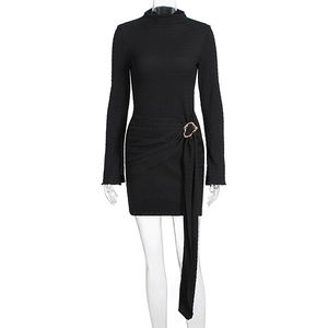 Détail de la taille froncée avec boucle en métal doré et drapé sur robe noire à manches