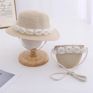 Detail of kids straw sun hat with delicate white lace flowers and matching crossbody bag