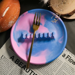 Plateau en résine marbré bleu et rose servant de repose-couverts avec une fourchette