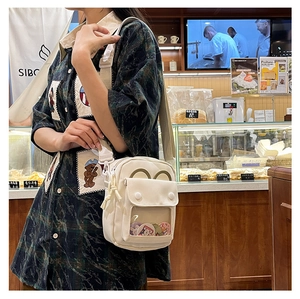 Cream white canvas crossbody ita bag with clear window and adjustable strap for pins