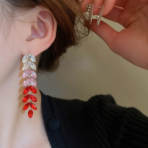 Close-up of elegant wheat-shaped drop earrings with a pink and red gradient tassel