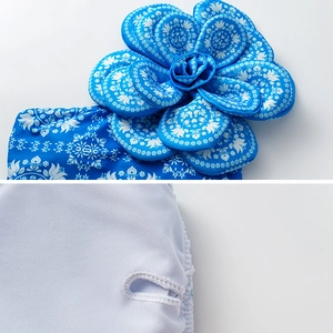 Close-up of blue swimsuit detailing 3D flower applique and fine mesh lining texture