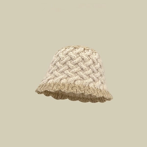Detailaufnahme von handgefertigtem Häkelhut mit Blumenmuster und beiger Wolltextur