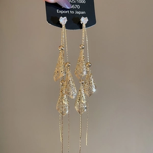 Detail of 18K gold plated silver tassel earrings with heart crystals and leaf charms