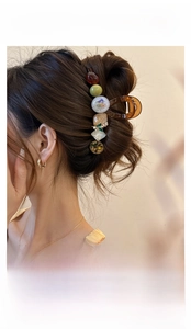 Détail d'une pince à cheveux avec fleurs séchées et perles en résine sur la coiffure