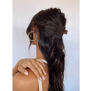 Detail view of a matte dark brown square hair claw clip on a model's half-up hairstyle