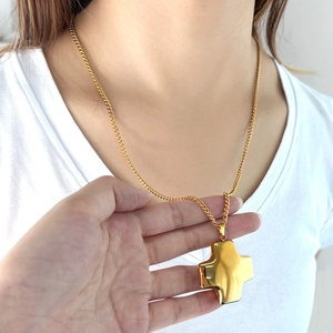 Chunky 3D polished gold cross pendant on curb chain necklace for modern street style