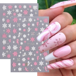 Pink and white Christmas nail art stickers with Cupid and snowflake designs on nails