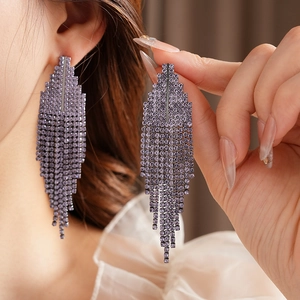 Close-up of elegant purple rhinestone long fringe earrings worn on model for style