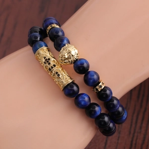 Bracciale occhio di tigre blu con testa di leone dorata e tubo croce su base legno