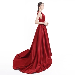 Elegant red satin evening gown with deep V-neckline and long sweeping train silhouette