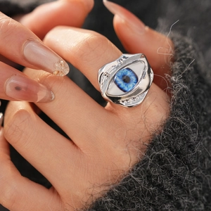 Detail of blue resin eye ring with irregular silver lava band worn on hand