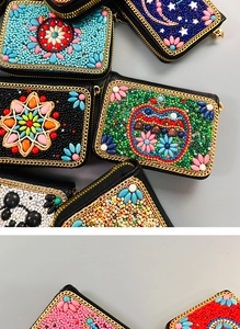 Close-up of handmade bohemian beaded card holders with colorful patterns and metal zippers