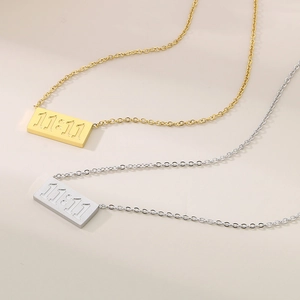 Vue détaillée des pendentifs dorés et argentés avec relief 11:11 sur chaîne fine