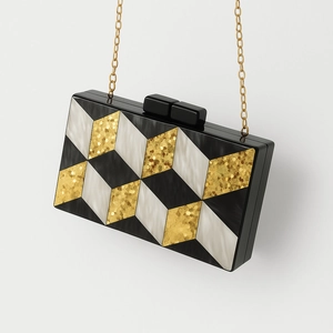 Detail of acrylic clutch bag with geometric diamond pattern and gold chain strap